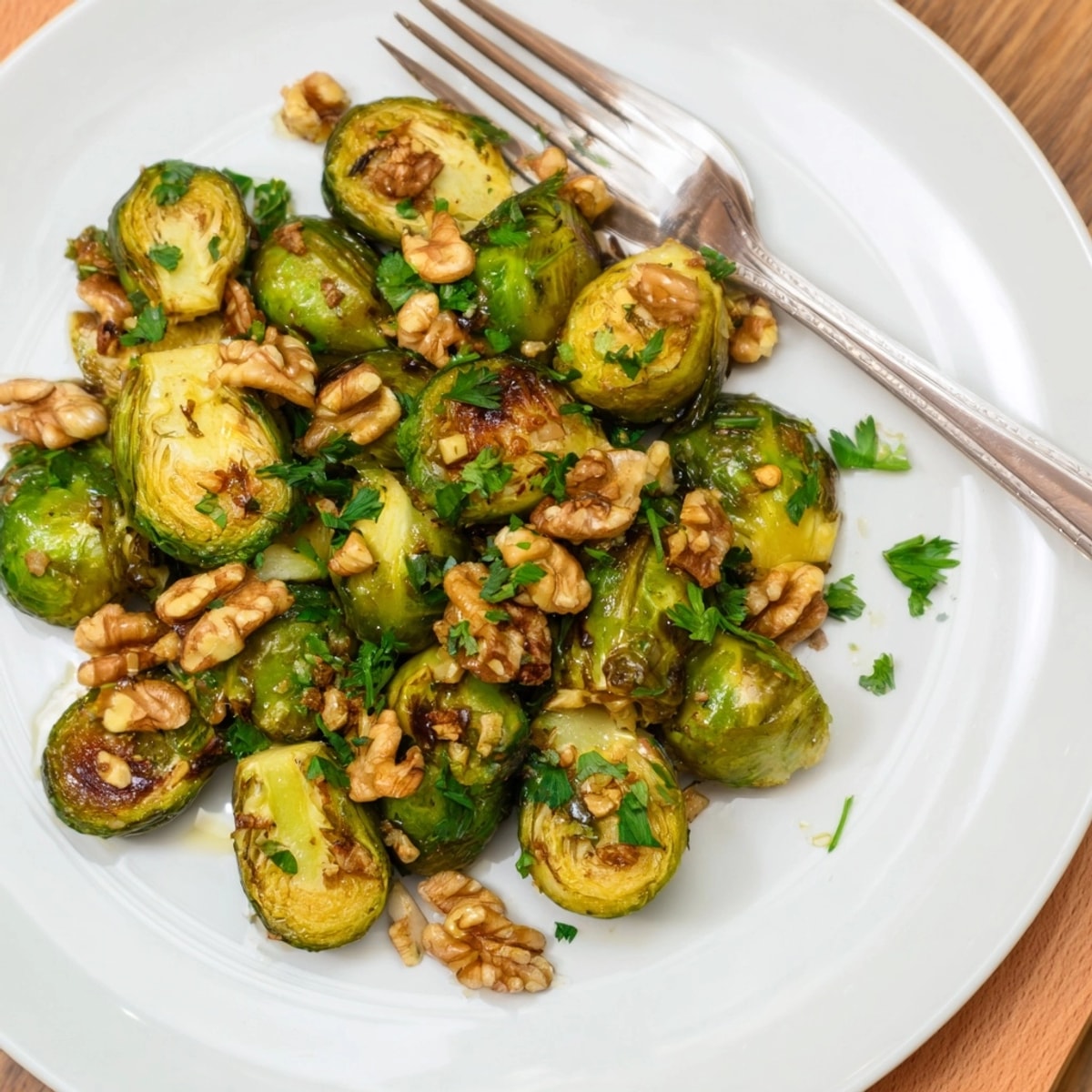 Close-up of glistening Maple Glazed Brussels Sprouts with Walnuts; sweet, savory perfection on parchment.