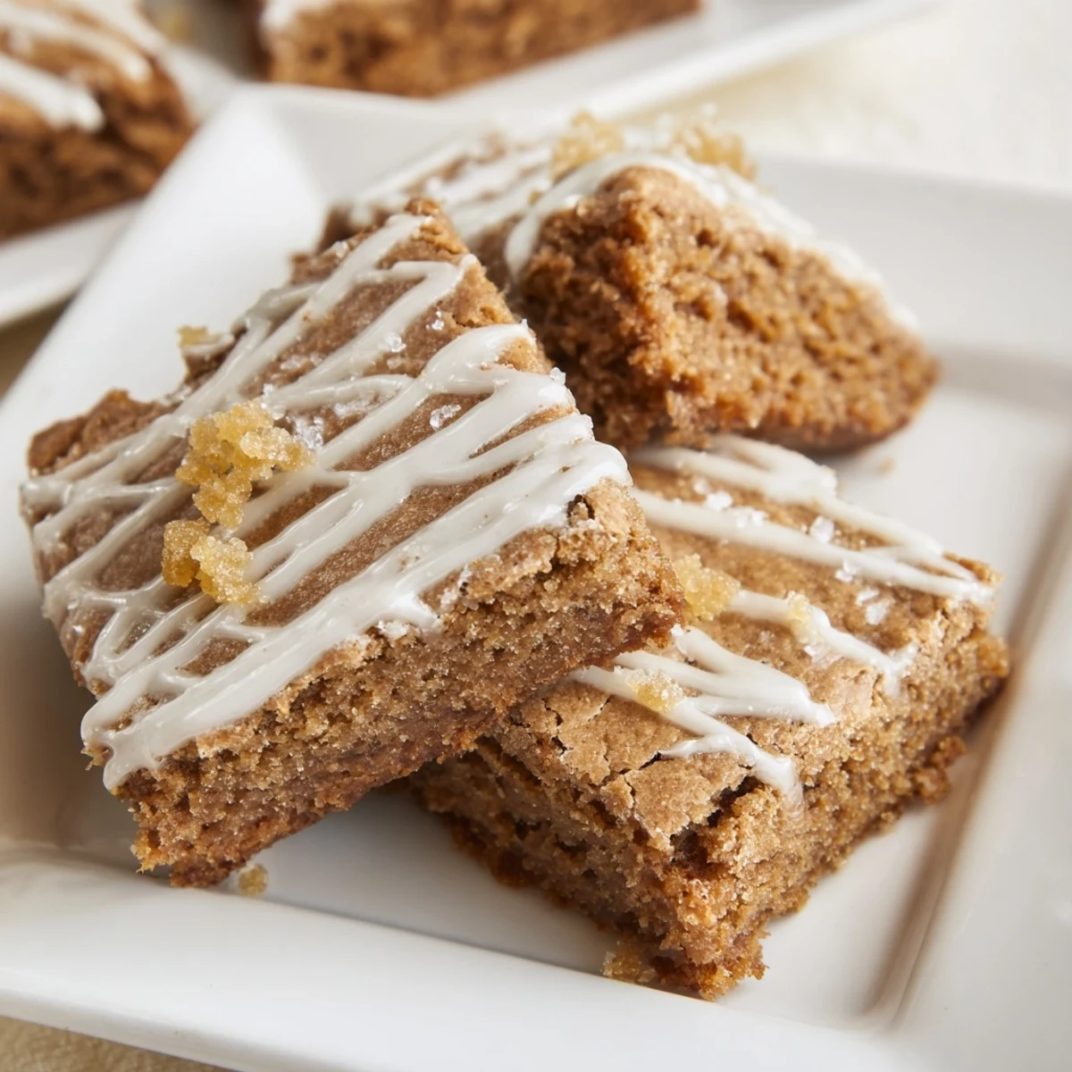 Close-up of golden gingerbread cookie bars, freshly baked and drizzled with creamy glaze.