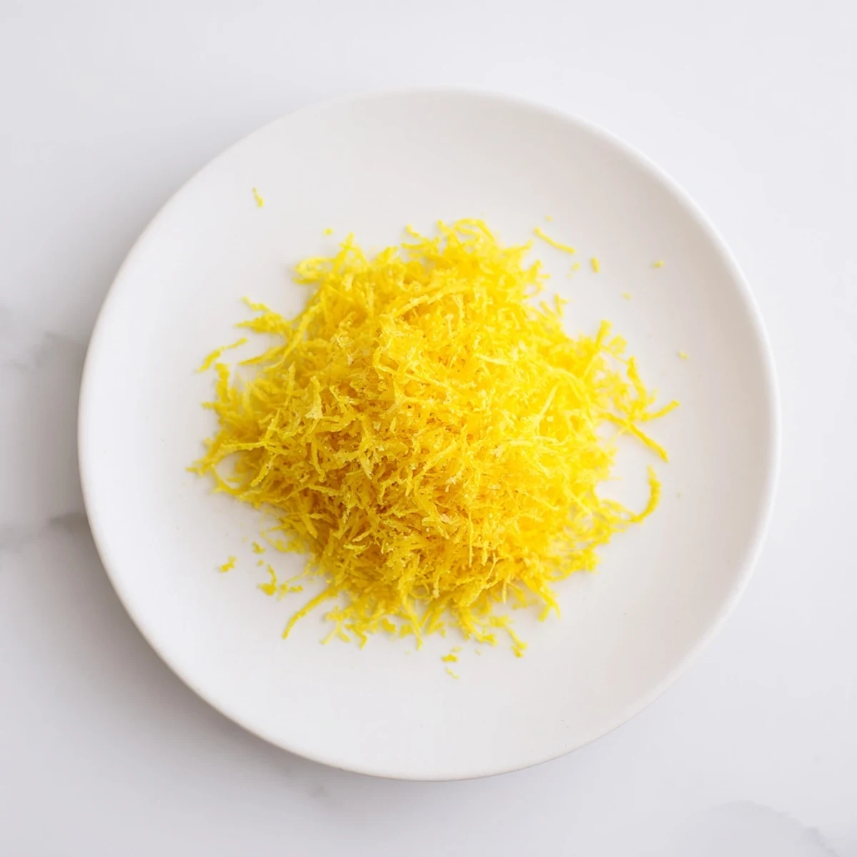 Freshly grated lemon zest, smelling wonderfully of citrus, a perfect, flavorful ingredient for baking.