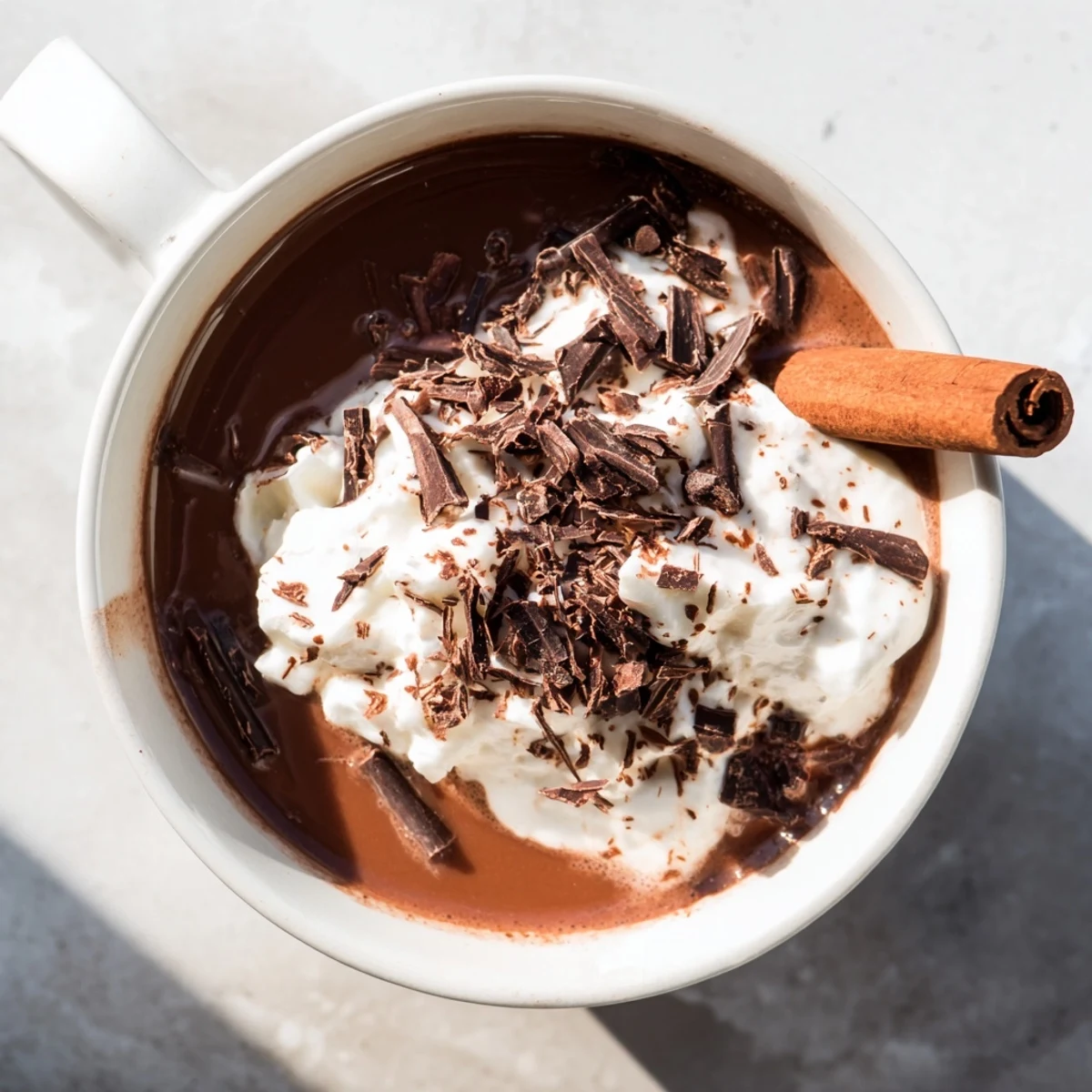 Steaming mug of Spiced Hot Chocolate, dark and decadent, topped with whipped cream and shavings.