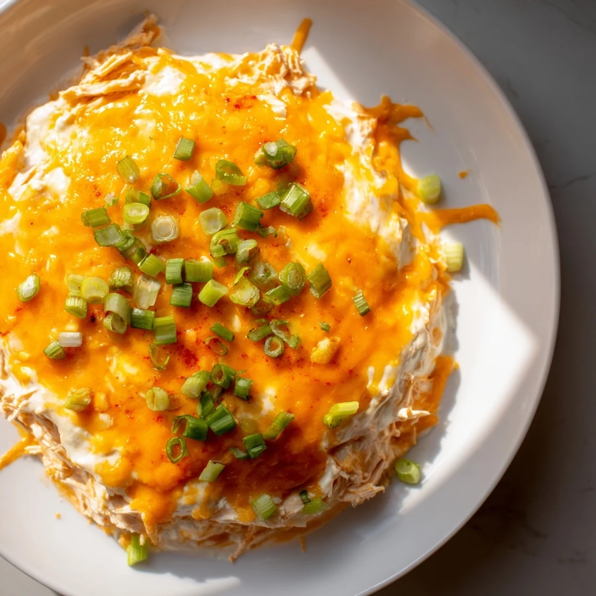 Steaming hot Spicy Buffalo Chicken Dip with bubbly cheese, ready for dipping those tortilla chips.