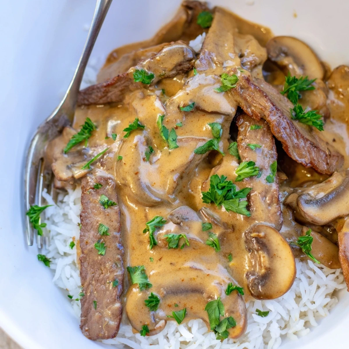 Tender beef strips in a rich stroganoff sauce served over fluffy basmati rice for dinner.