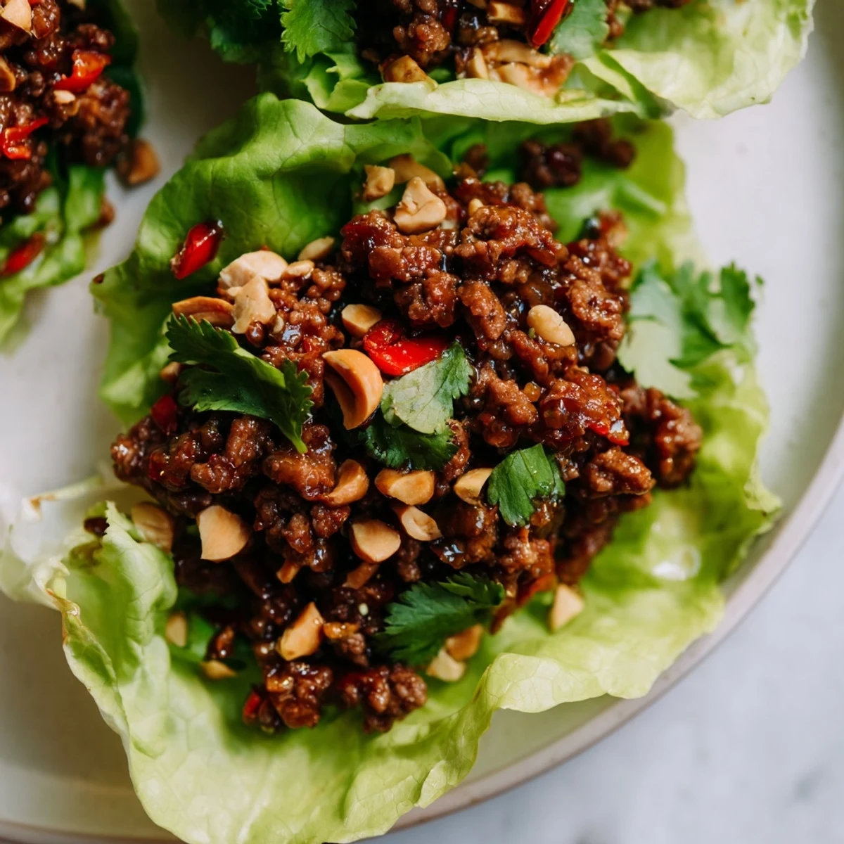 Ground beef sautéed with ginger and garlic in savory hoisin sauce, spooned into crisp butter lettuce cups for a fresh bite.