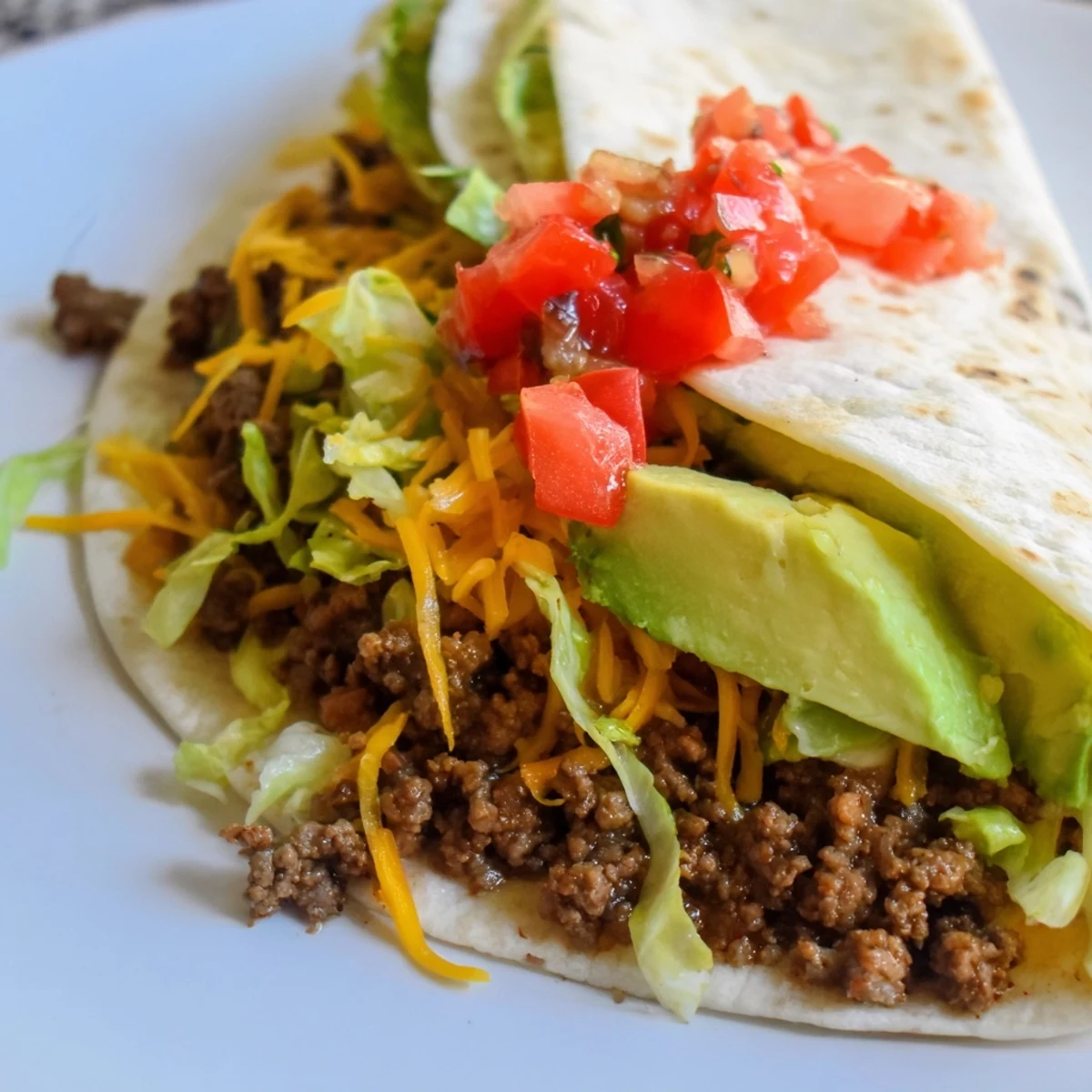 Close-up of sizzling beef filling for Beef Tacos with Soft Tortillas being spooned onto a warm tortilla.