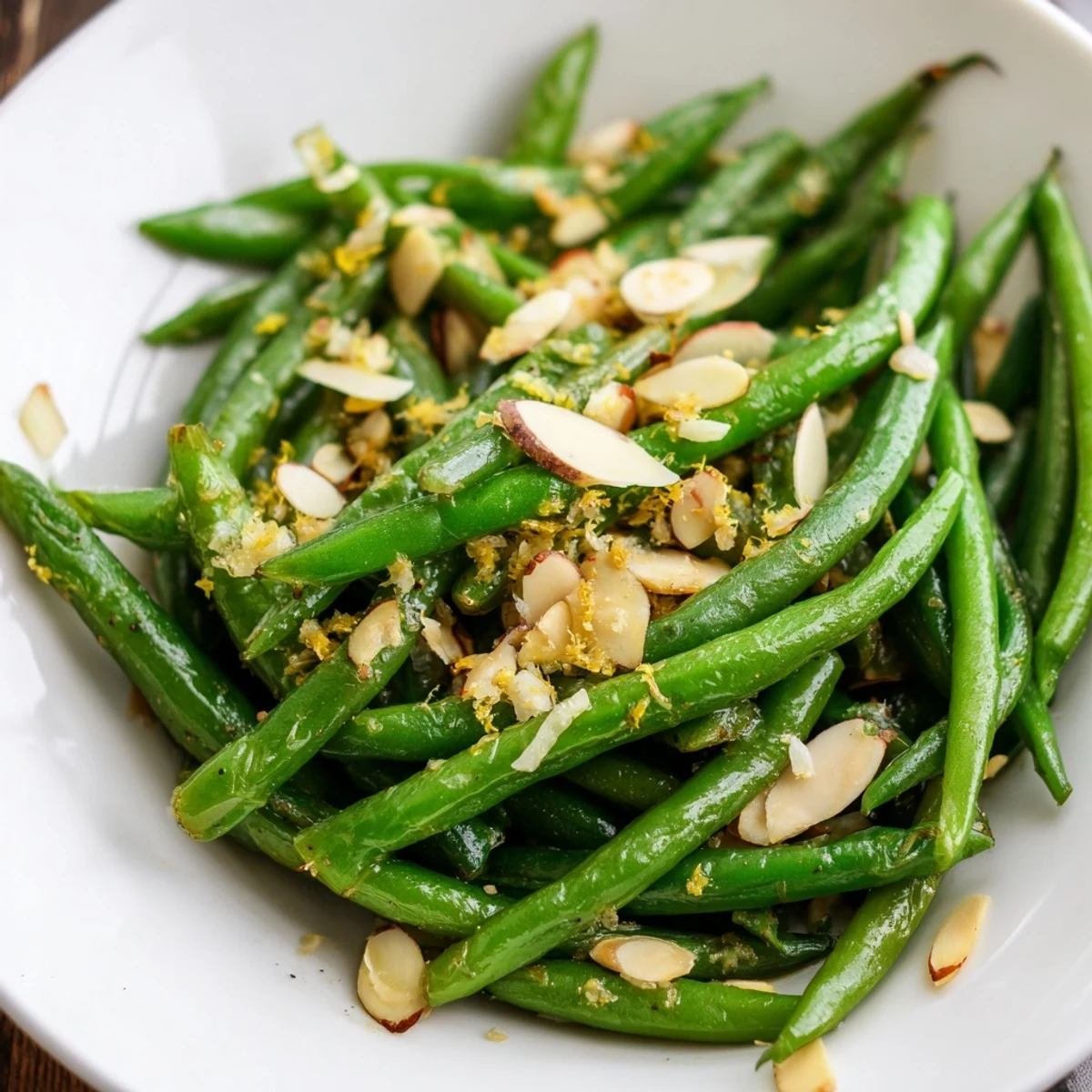 Tender-crisp green beans with lemon and almonds sautéed in garlic butter on a platter.