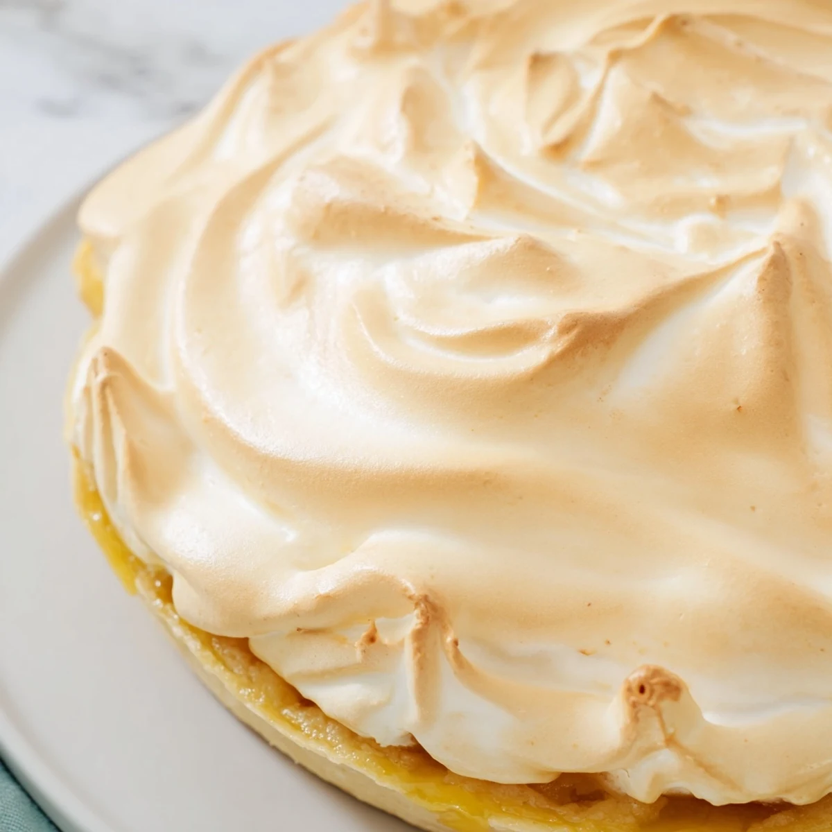 Golden slices of apple filling peek from under a toasted meringue topping in this Irish Apple Amber Tart.