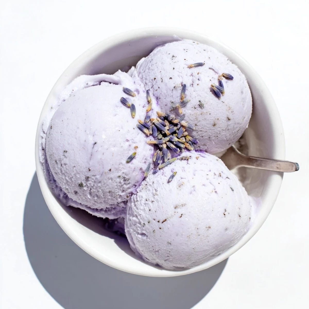 Lavender ice cream is served in a waffle cone with a sprig of lavender, highlighting its fragrant, elegant, and creamy texture.