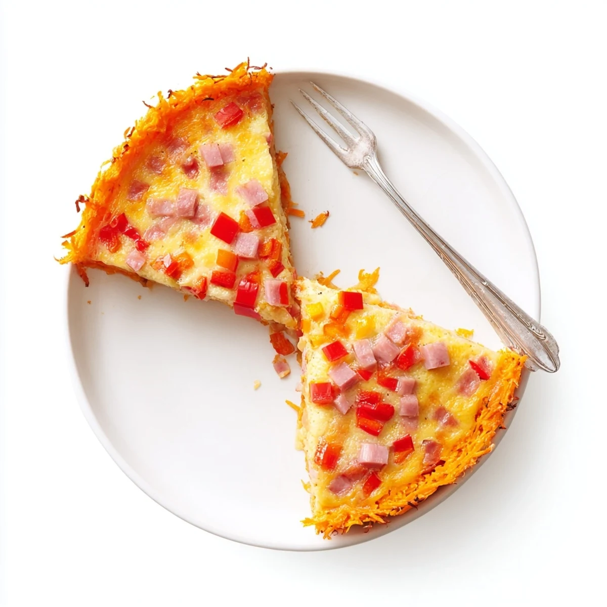 A slice of Red Capsicum and Ham Quiche with Sweet Potato Crust is plated next to a green salad for a light meal.