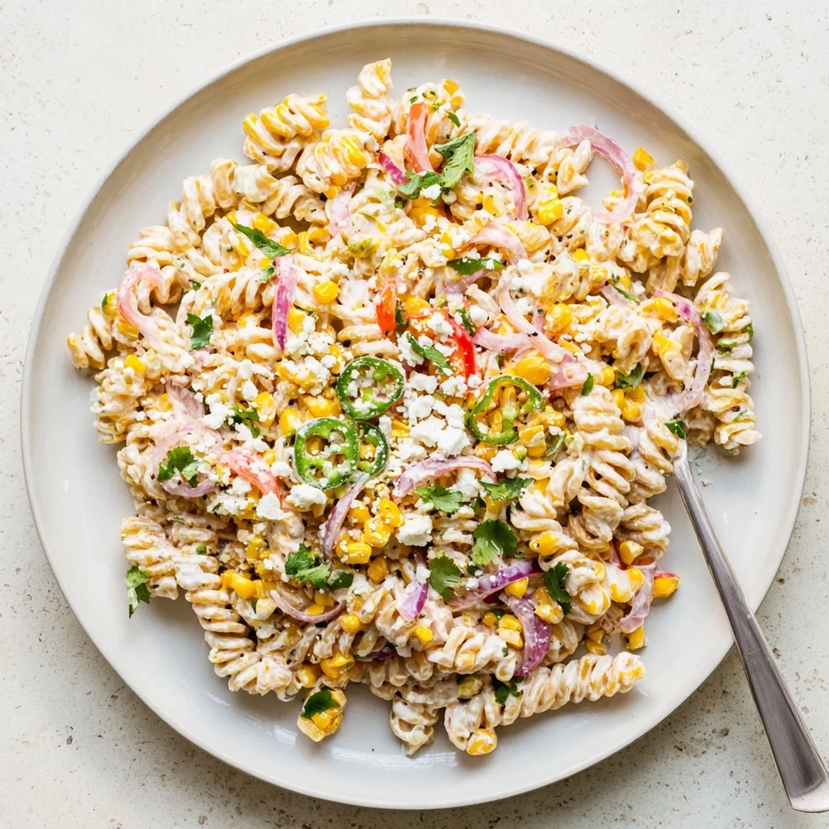 Bowl of Mexican Street Corn Pasta Salad with rotini pasta, jalapeños, and a tangy, smoky dressing perfect for summer.