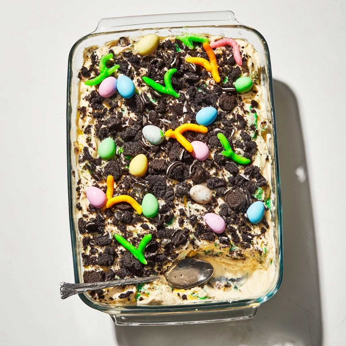 Top view of Easter Dirt Cake Casserole with crushed Oreos, creamy pudding, and candy eggs for a whimsical dessert.