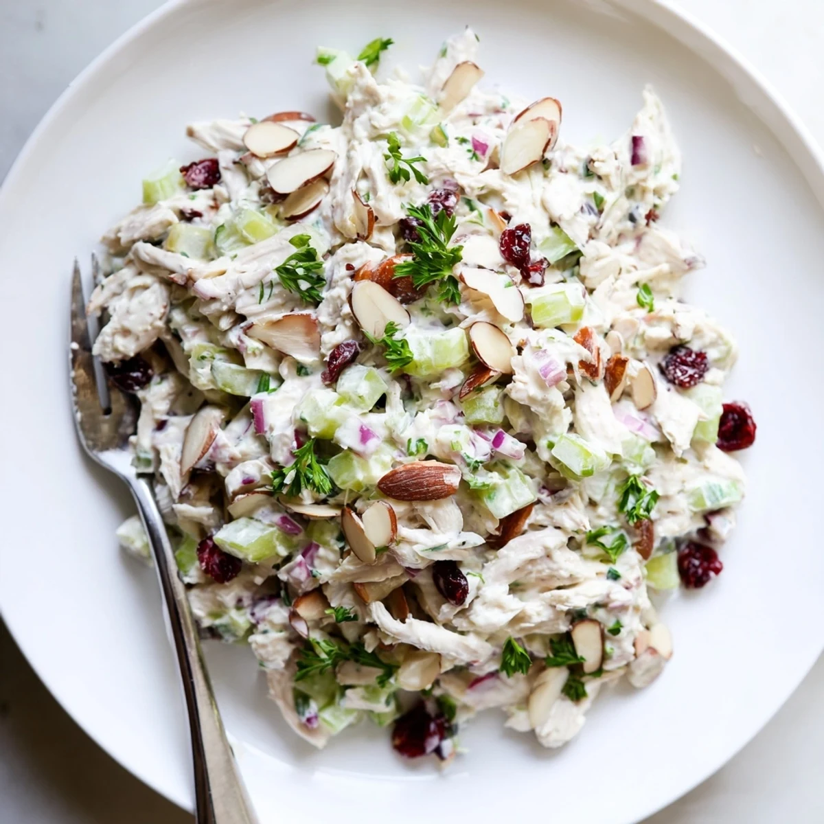 Creamy Greek yogurt rotisserie chicken salad with crisp red peppers and celery in a white bowl