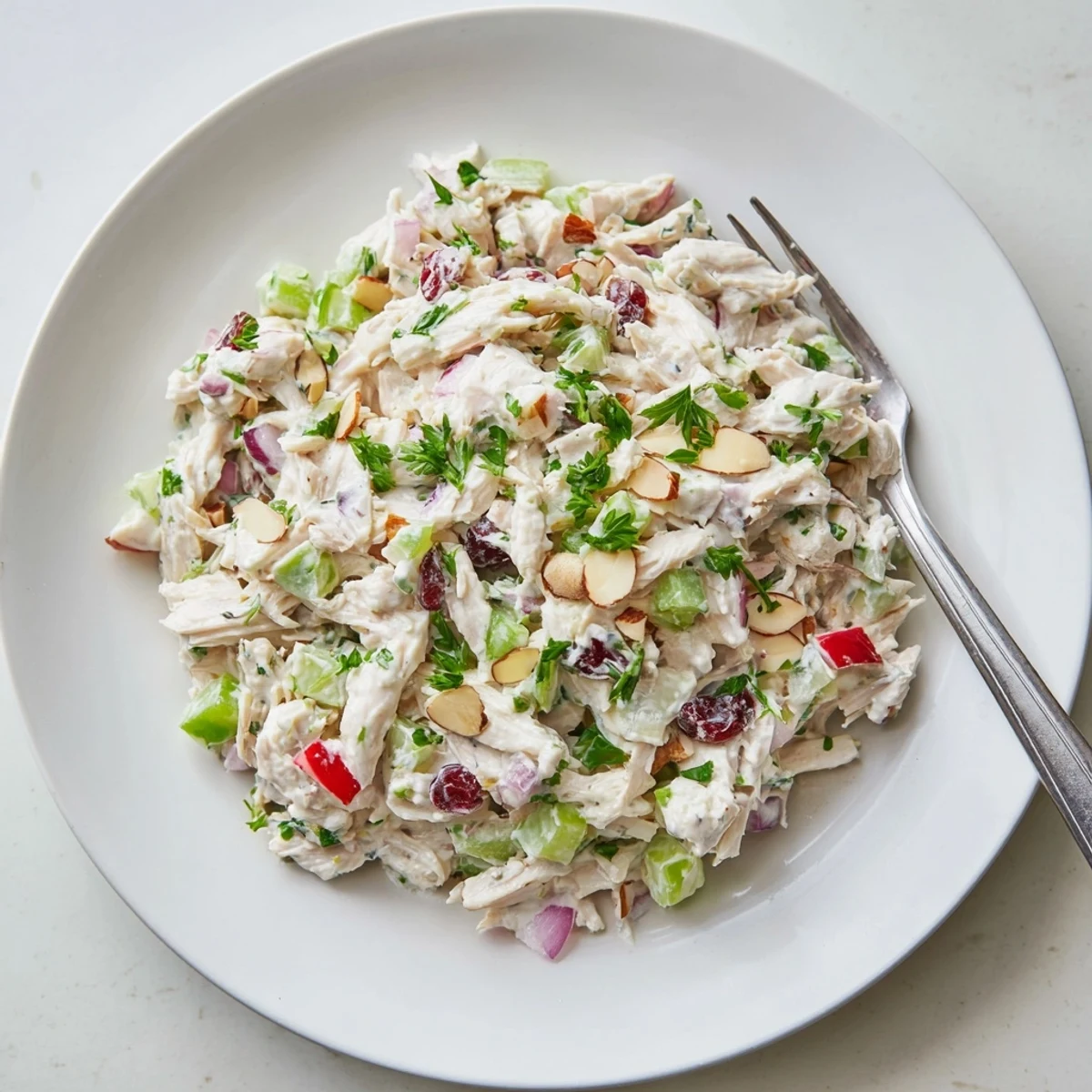 Protein-packed Greek yogurt rotisserie chicken salad served on fresh greens with colorful diced vegetables