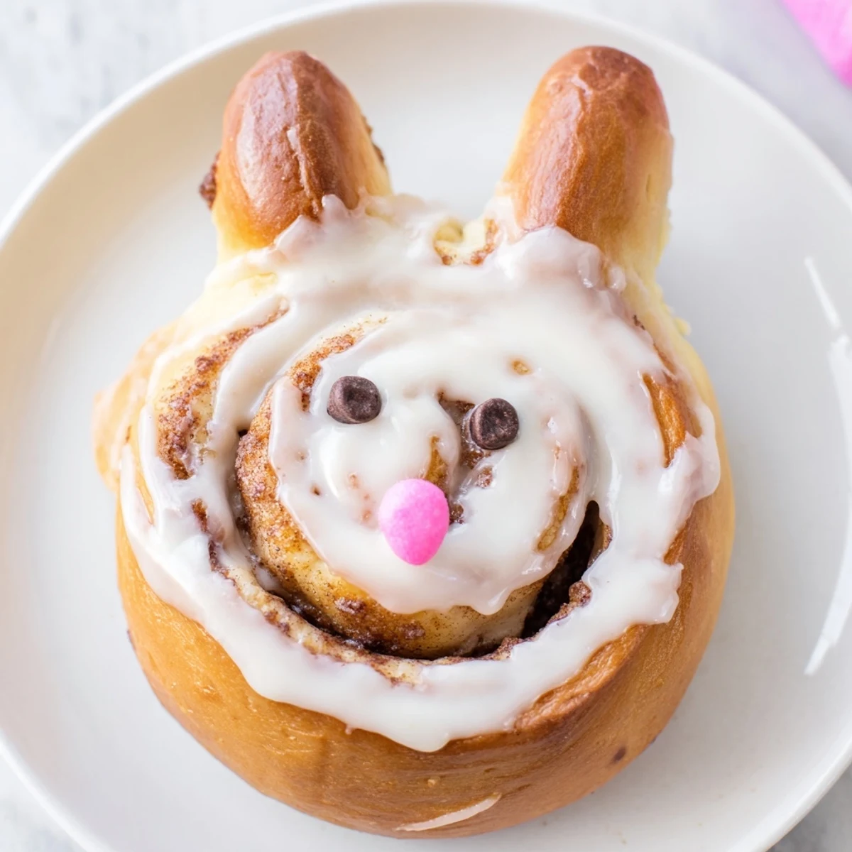 Warm homemade Easter Bunny Cinnamon Rolls on white plate with cinnamon sugar peeking through layers