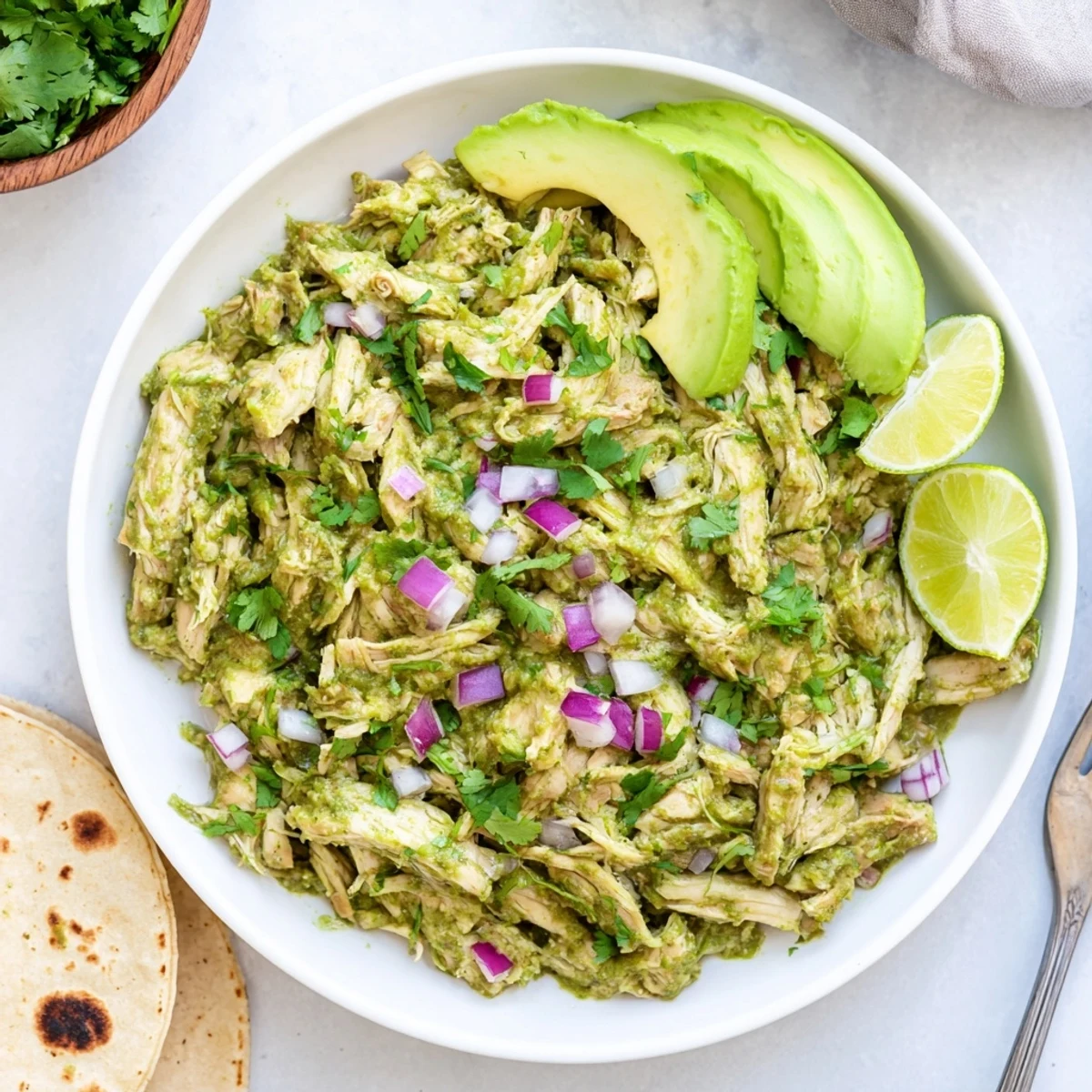 Golden chicken simmered in vibrant green salsa verde sauce topped with creamy avocado slices