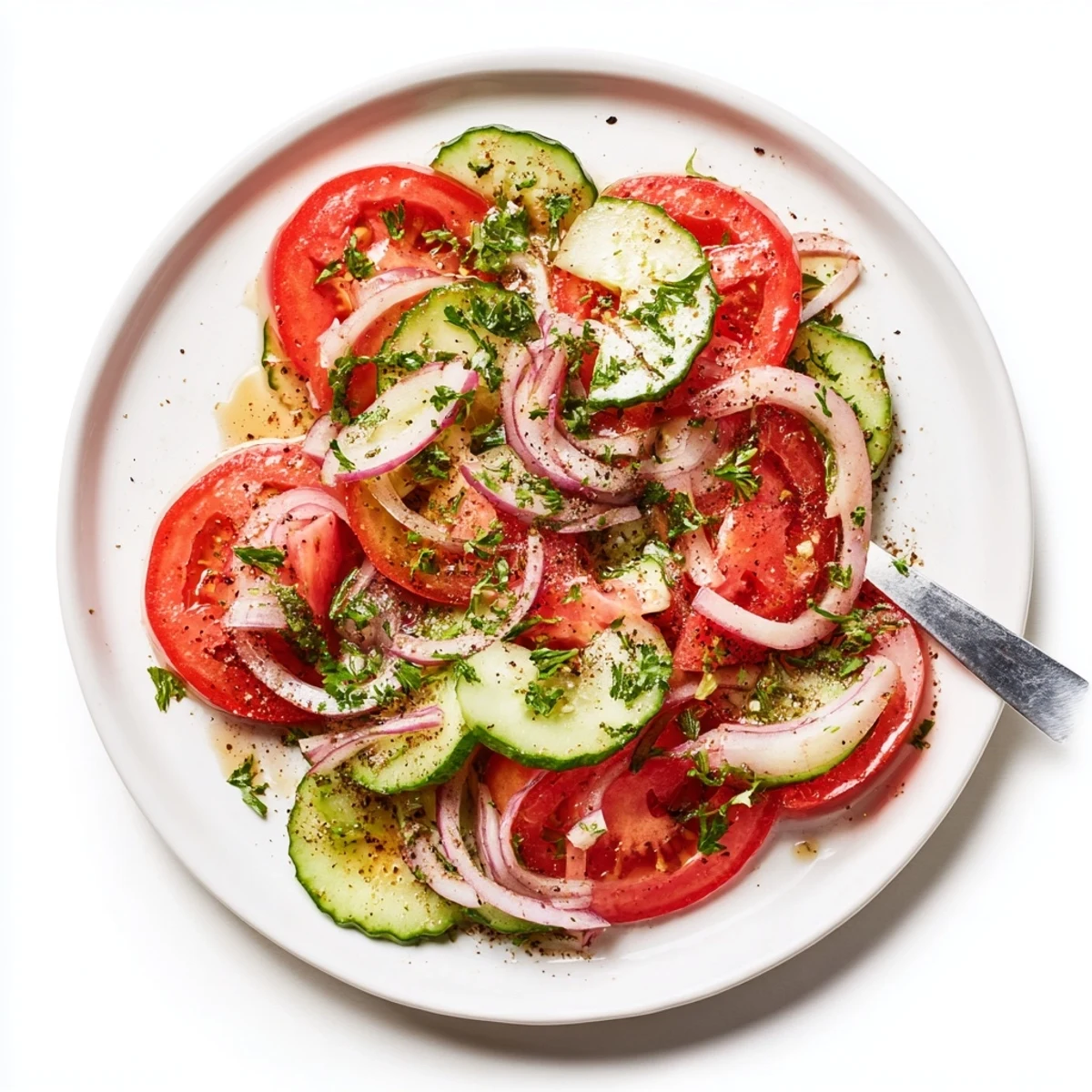 Crisp tomato cucumber and onion salad bowl featuring colorful vegetables dressed in olive oil