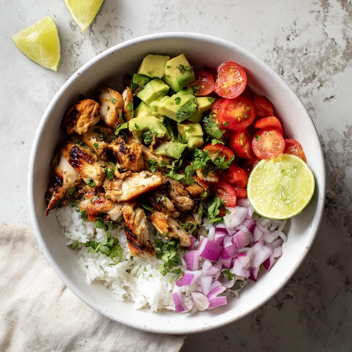 Vibrant chicken rice bowl featuring glazed honey lime meat, red onion, tomatoes, and buttery avocado