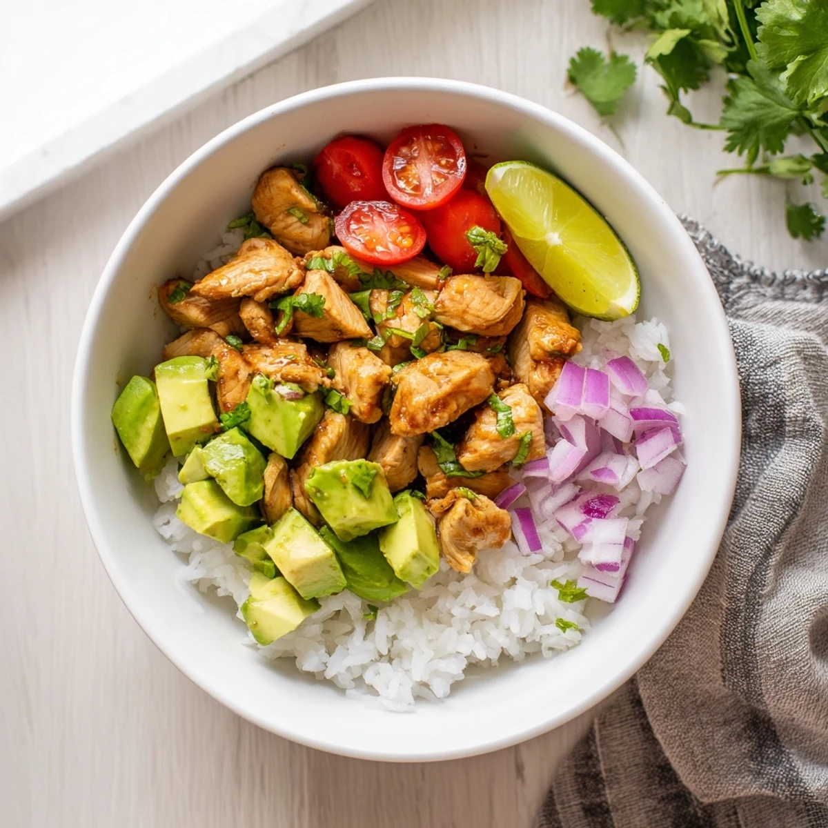 Zesty honey lime marinated chicken rice bowl topped with fresh cilantro and ripe avocado chunks