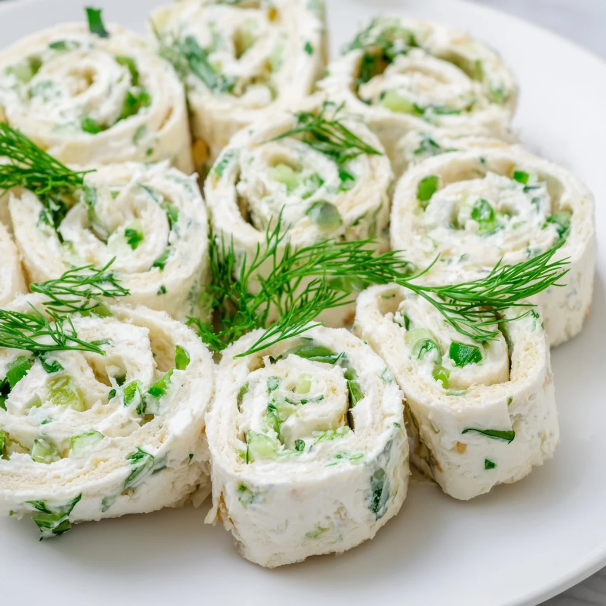 Party appetizer pinwheels arranged on serving board with creamy center filling showing