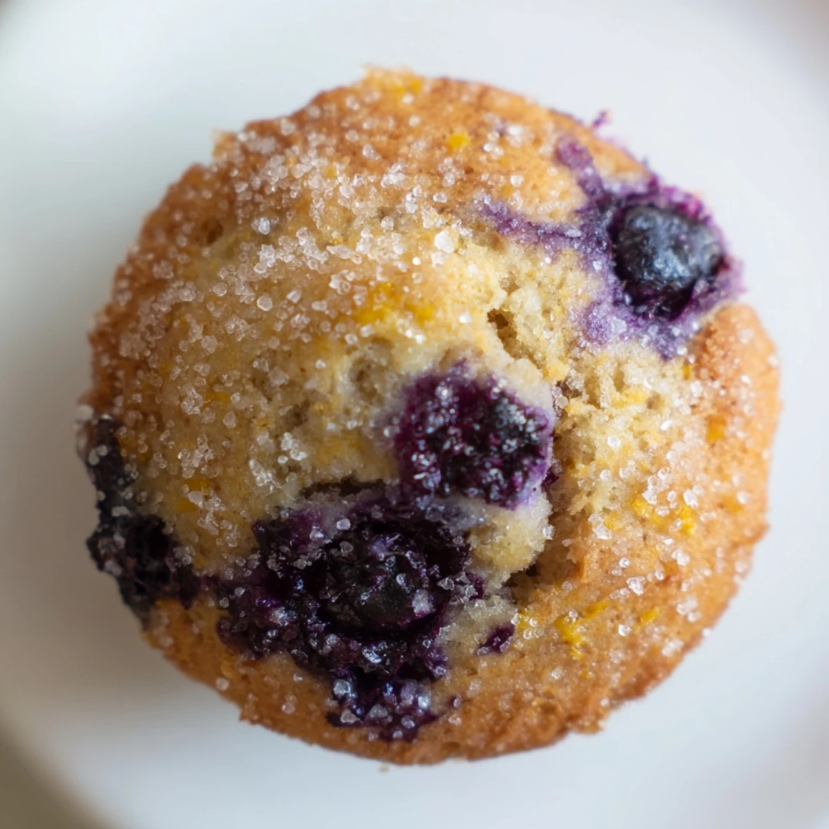 Moist lemon blueberry muffins bursting with juicy berries on a rustic plate
