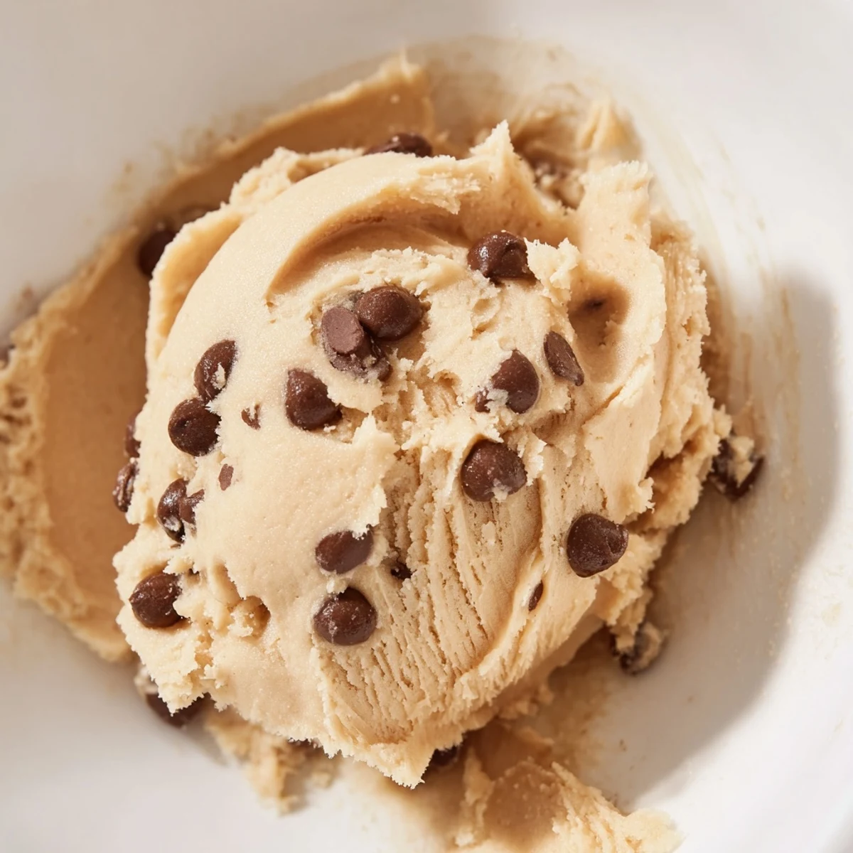 Edible chocolate chip cookie dough in a mixing bowl ready for spooning and snacking