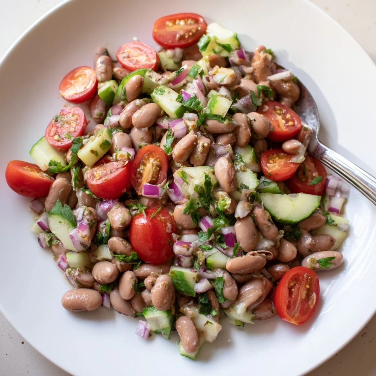 Creamy pinto beans mixed with diced cucumber tomatoes and cilantro in a zesty vinaigrette