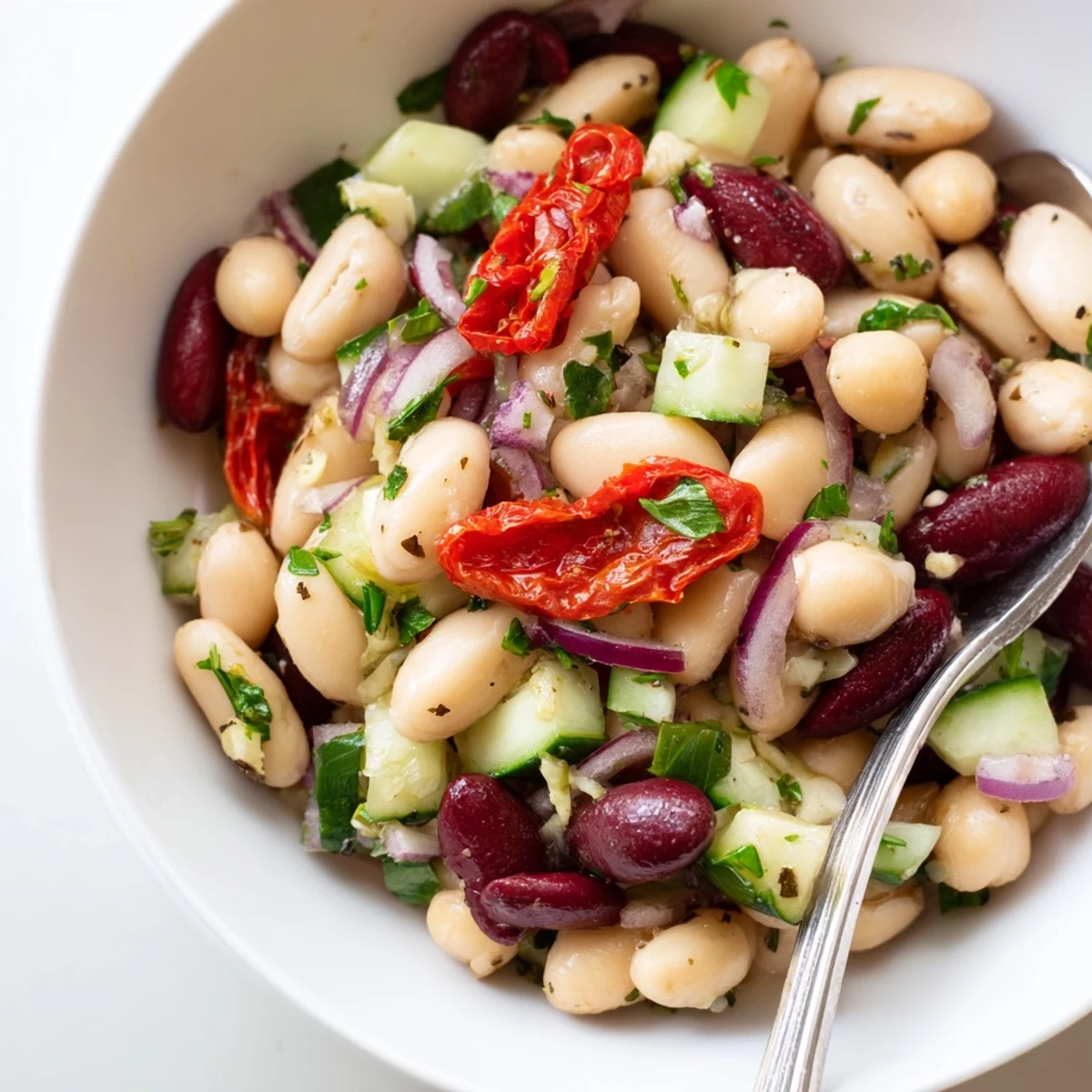 Dense Bean Salad With Sun Dried Tomatoes piled in rustic bowl, vibrant