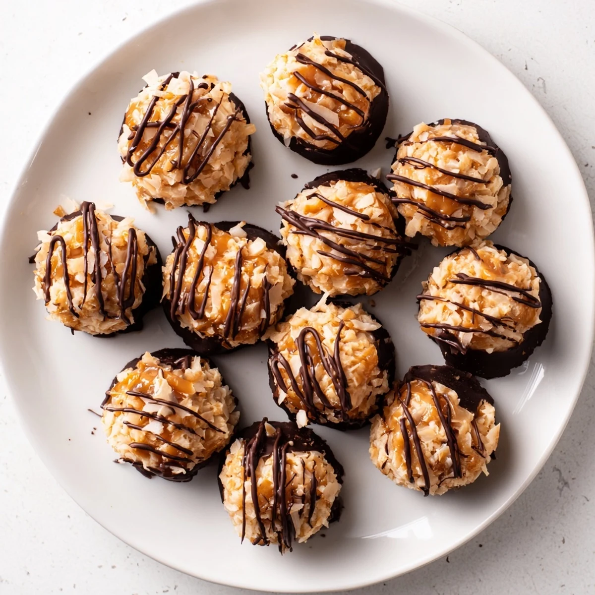 Close up of no bake Samoa bites topped with dark chocolate swirls and sweet caramel coconut layer