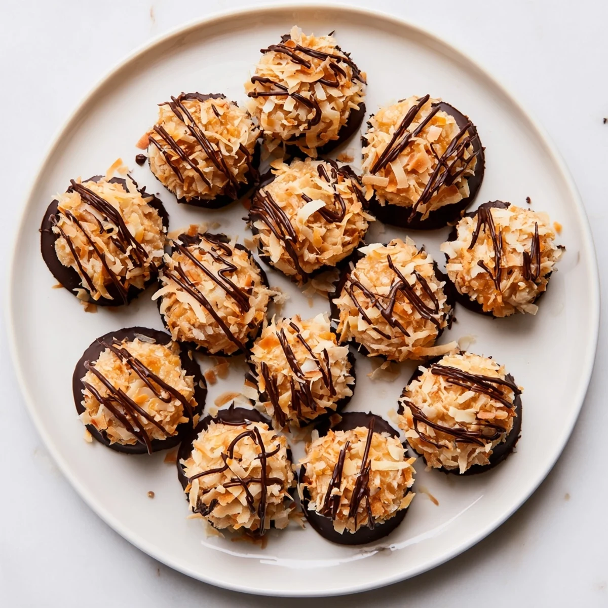 Rich chocolate dipped no bake Samoa bites arranged on parchment with gooey caramel coconut centers showing