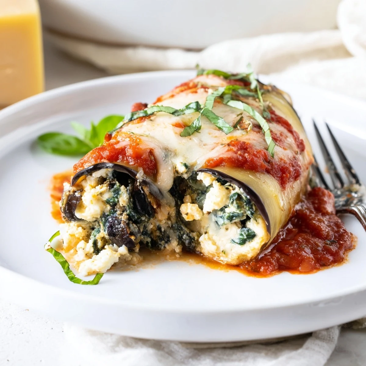 Healthy Eggplant Rollatini bubbling with marinara, melted mozzarella, and fresh basil