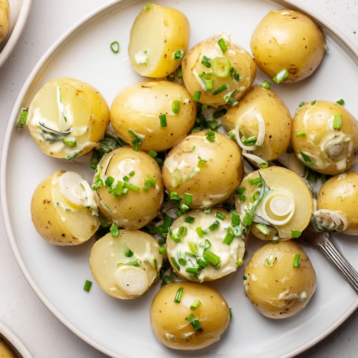 Sour Cream And Onion Potato Salad piled in bowl, creamy tangy herbs  