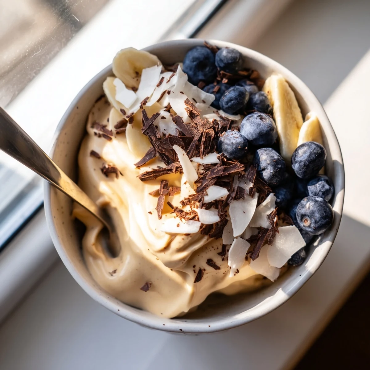 Vibrant banana nice cream recipe scooped into glasses showing smooth dairy-free texture with chopped nuts