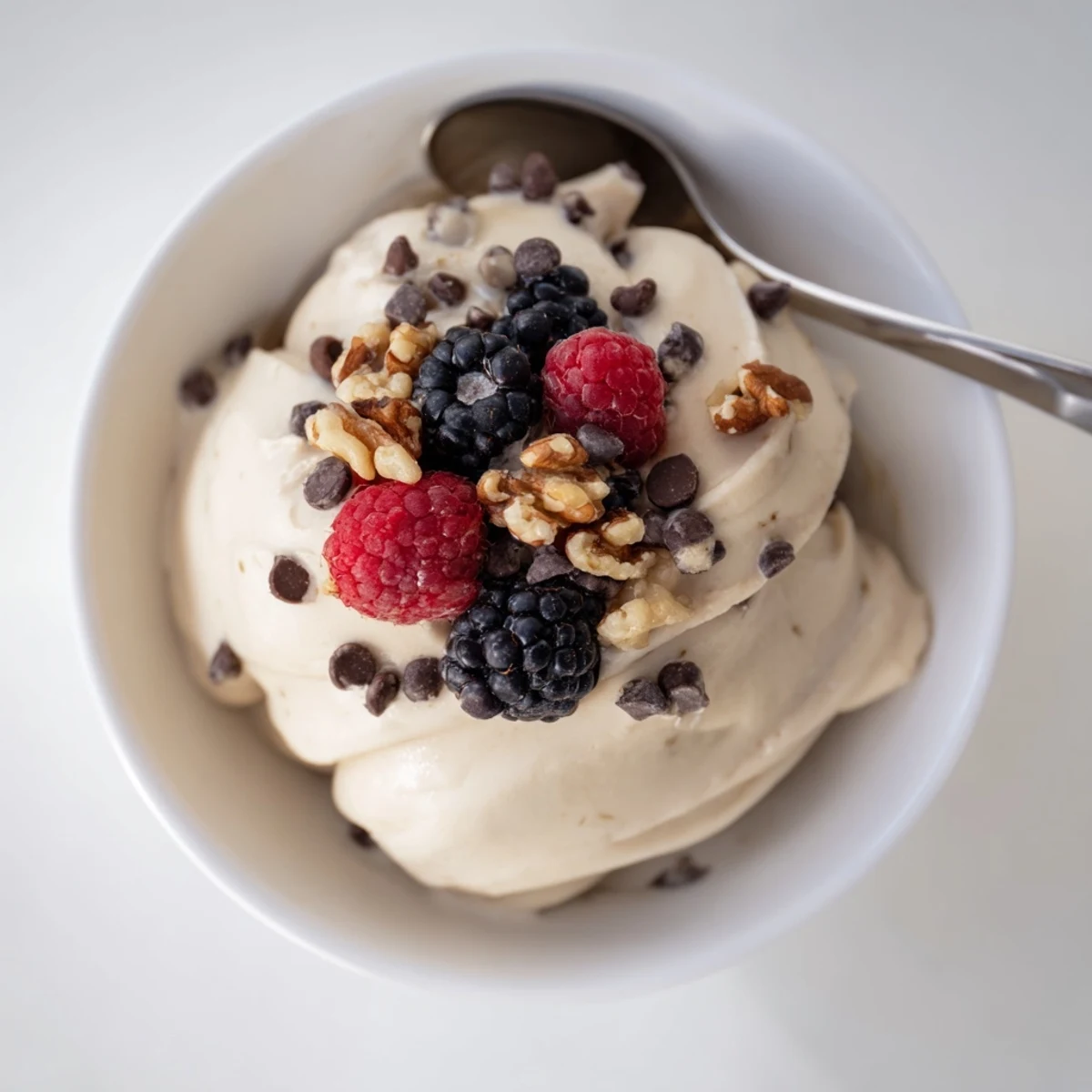 Vegan banana nice cream served in a glass with a spoon and sliced bananas