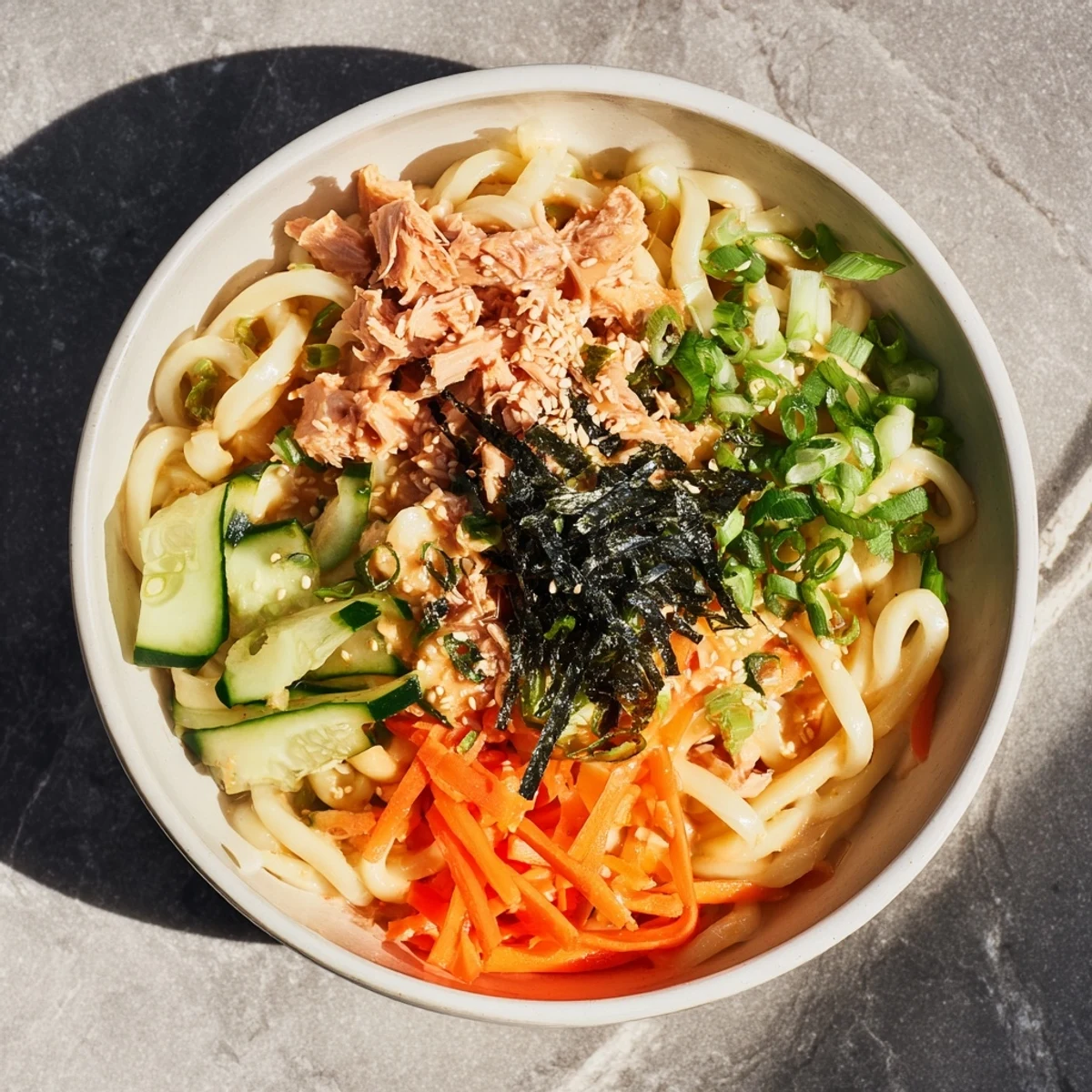 Chilled spicy tuna udon featuring thick noodles coated in creamy sriracha mayonnaise