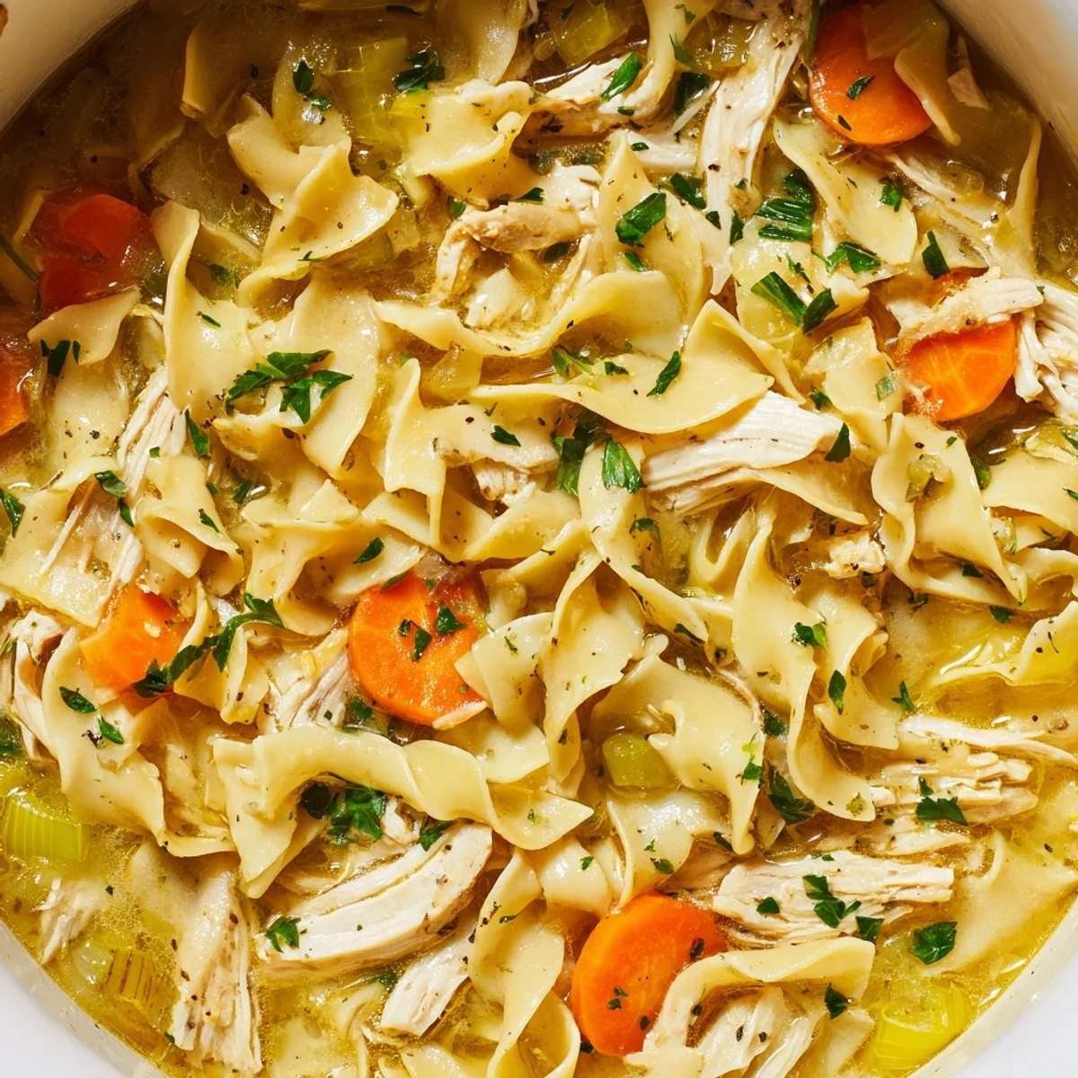 Creamy one pot chicken and noodles dish garnished with fresh chopped parsley