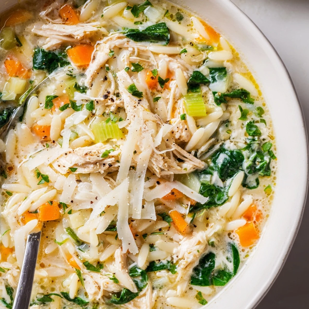 Steaming bowl of silky broth, tender chicken, spinach, Creamy Chicken Florentine Soup With Orzo