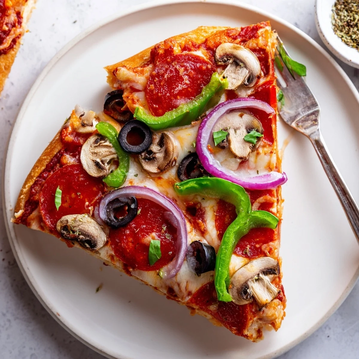 Sliced Focaccia Pizza Supreme showing airy dimpled crust, basil, olive oil sheen.