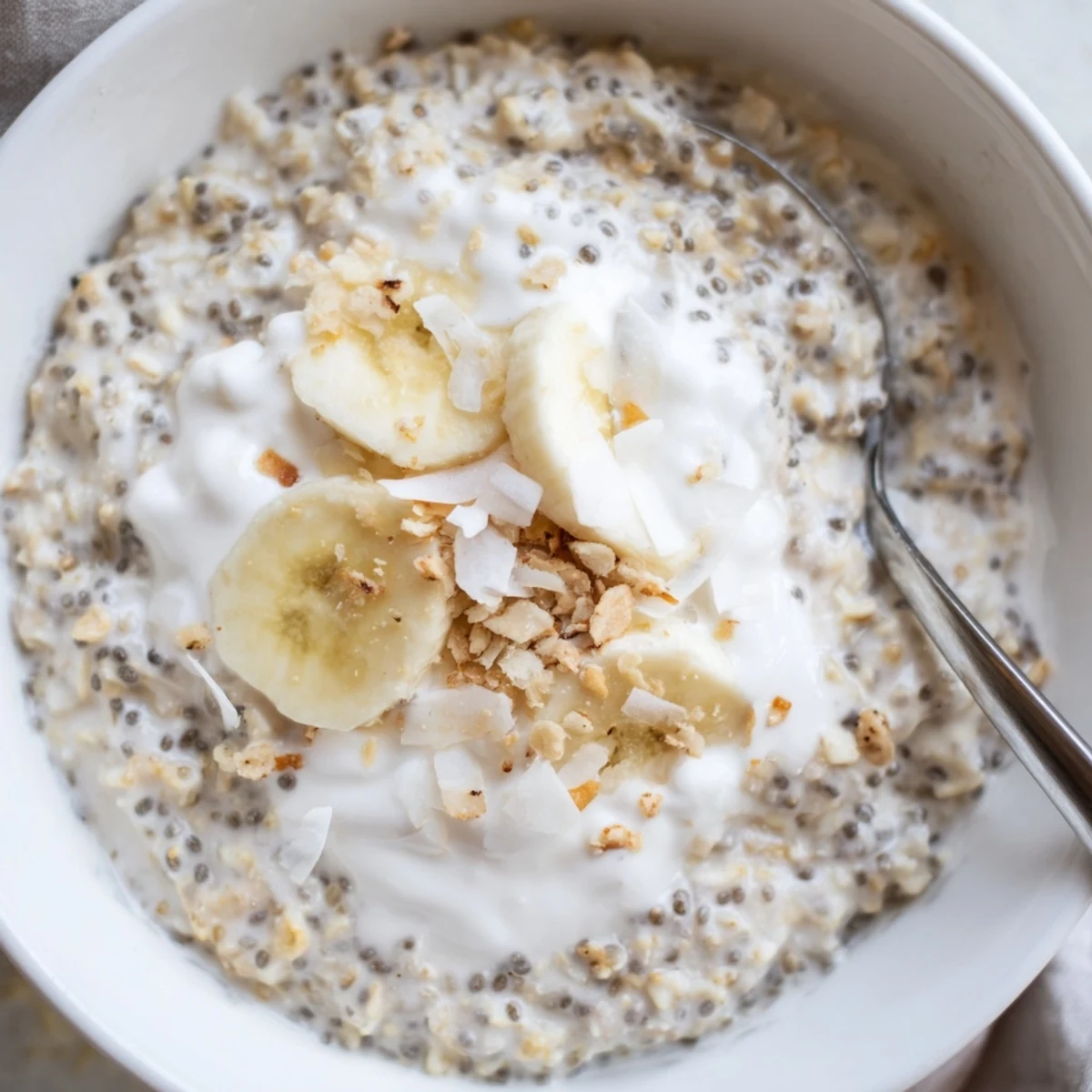 Coconut Cream Pie Overnight Oats topped with toasted coconut and banana slices