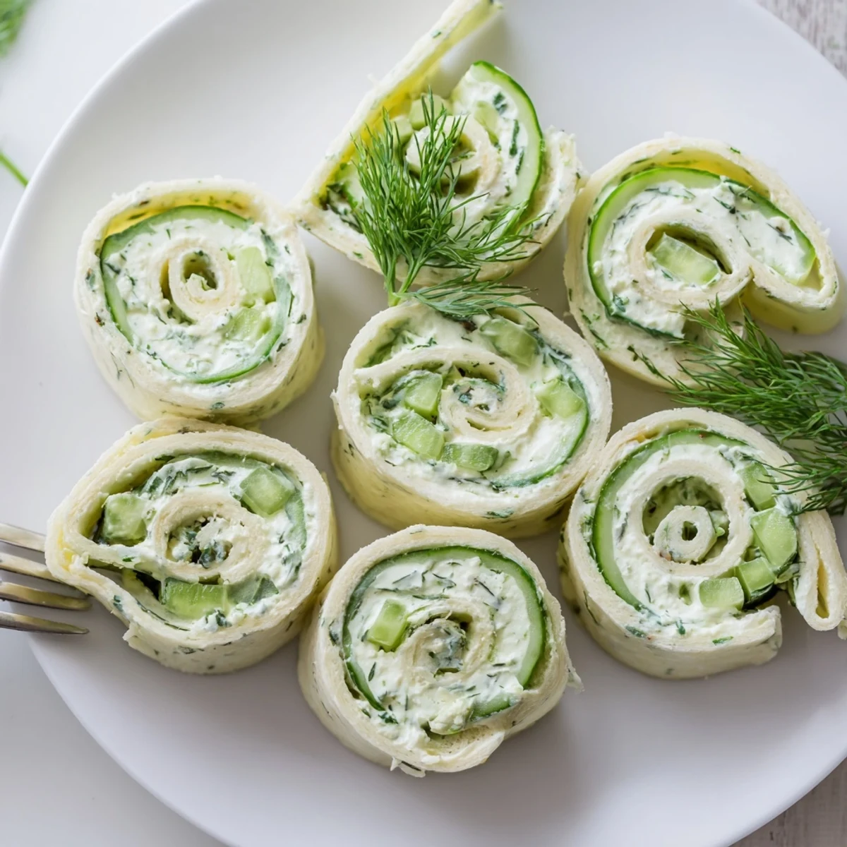 Cucumber And Dill Pinwheels chilled on a platter, creamy filling, herb fragrance