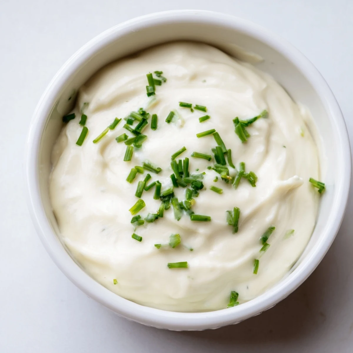 Zesty horseradish sauce in a small serving bowl alongside sliced roast beef