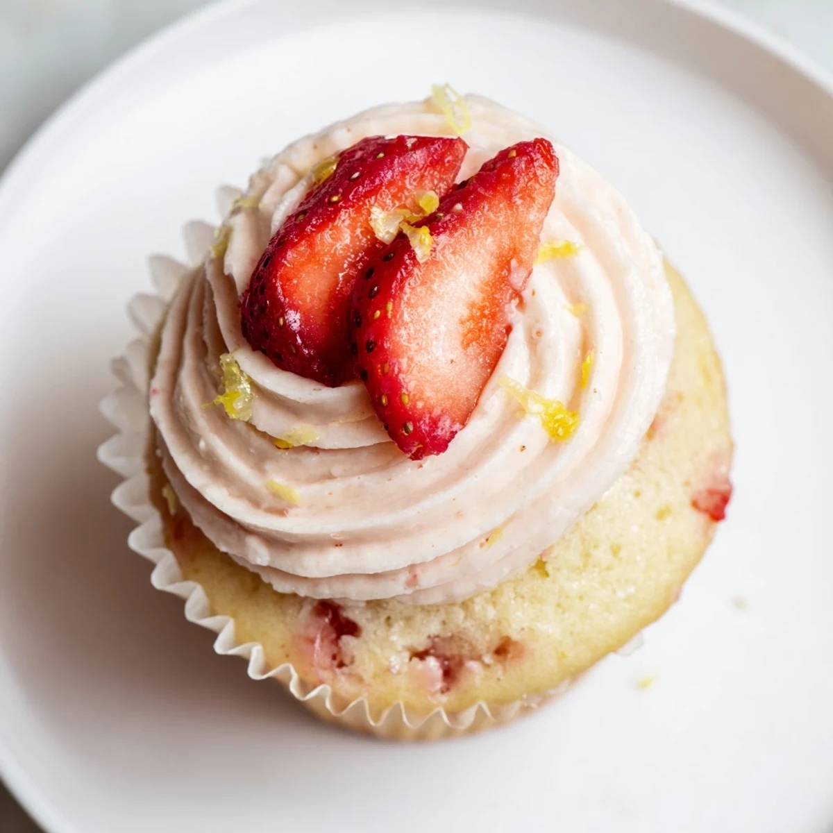 Close up of moist strawberry lemonade cupcakes with strawberry lemon buttercream and a strawberry garnish
