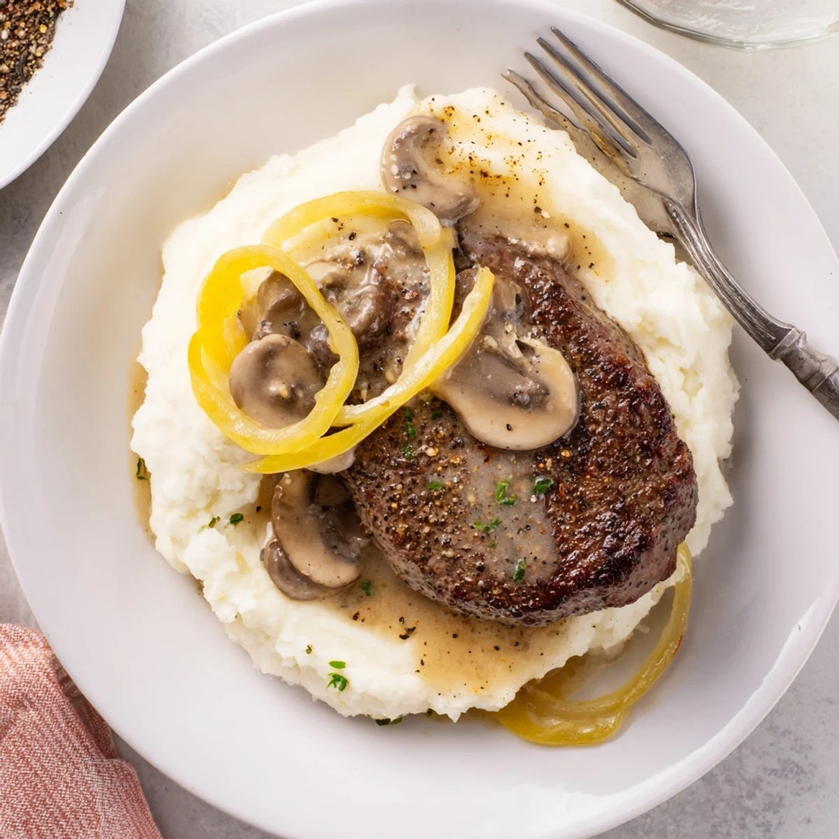 Country Style Smothered Cube Steak Recipe with silky onion-mushroom gravy over mashed potatoes