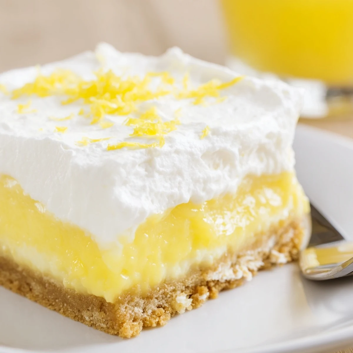 Slice of Lemon Lush Cake on plate, tangy, smooth, ready to serve