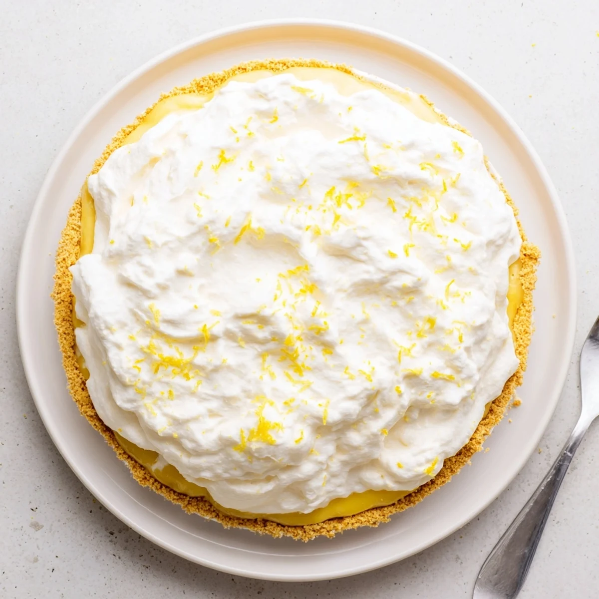 Real lemon pie with silky golden filling in a buttery graham cracker crust