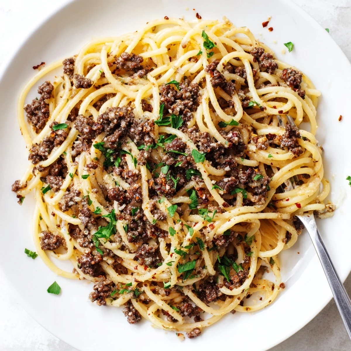 Garlic butter pasta with ground beef topped with Parmesan and fresh parsley