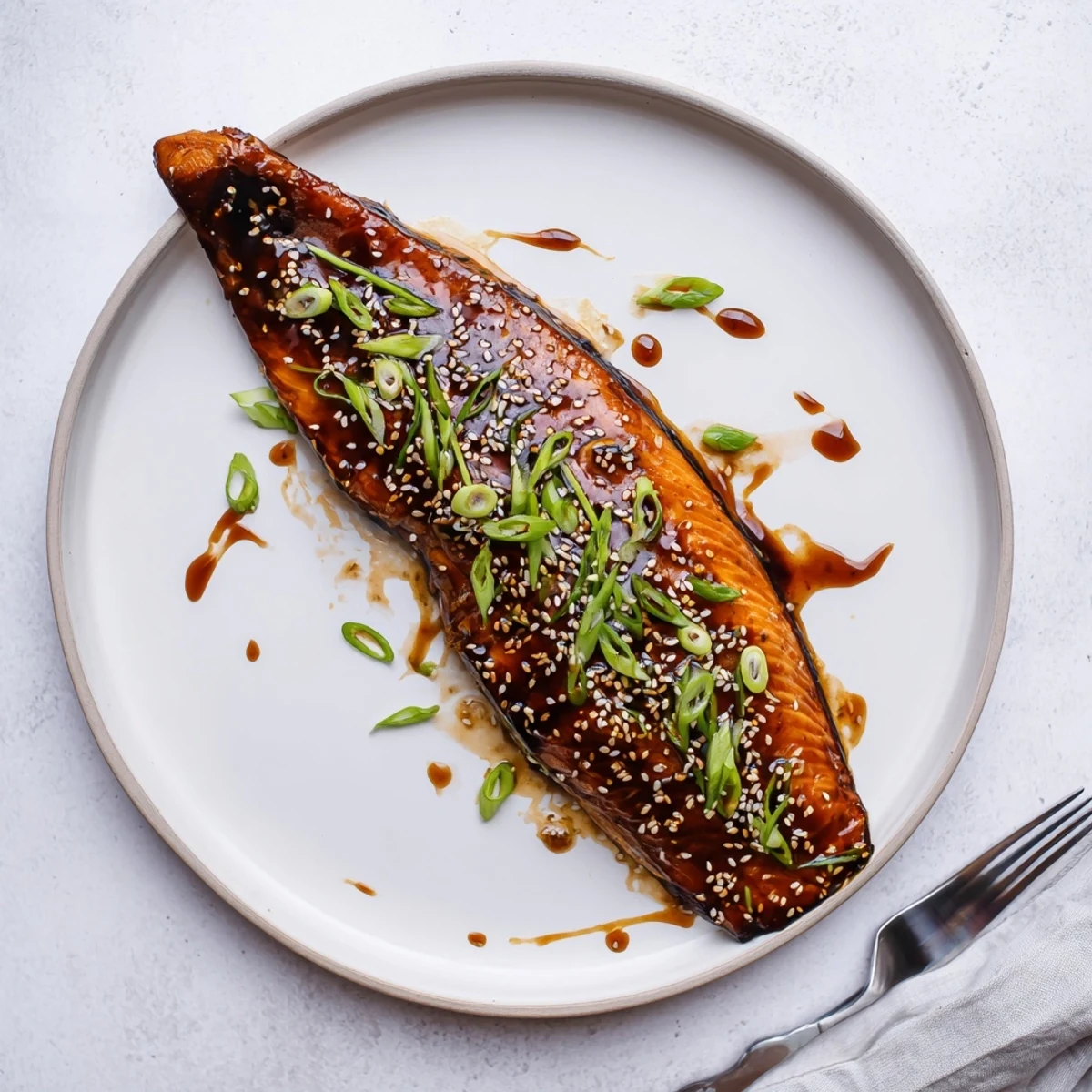 Juicy gluten free teriyaki salmon topped with sesame seeds and sliced spring onions