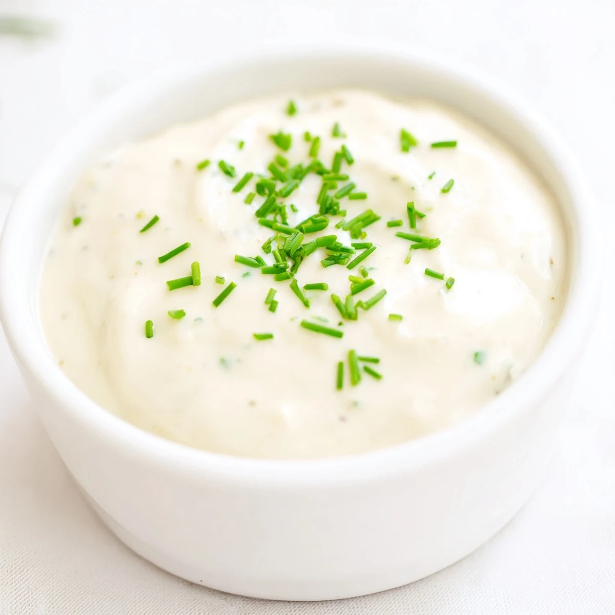 Zesty horseradish sauce in a small serving bowl alongside sliced roast beef