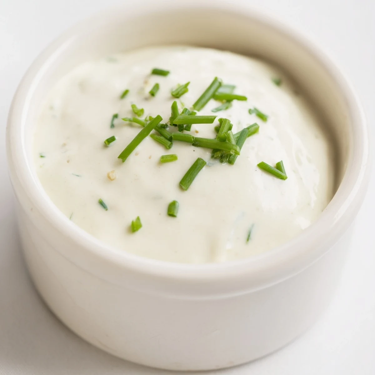 Creamy homemade horseradish sauce with a smooth white texture and fresh herb garnish