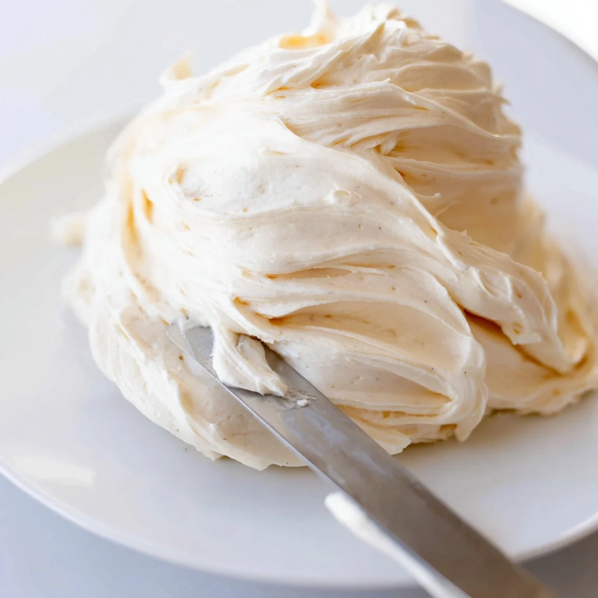 Glossy Italian meringue buttercream spread generously over a tall celebration cake
