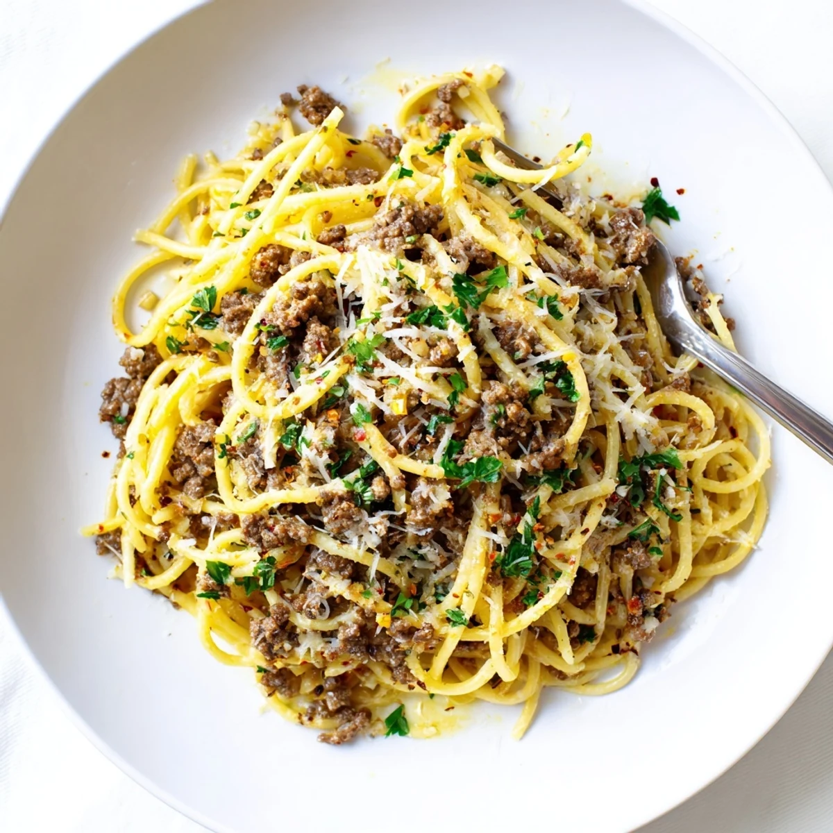 Garlic butter pasta with ground beef topped with freshly grated Parmesan cheese
