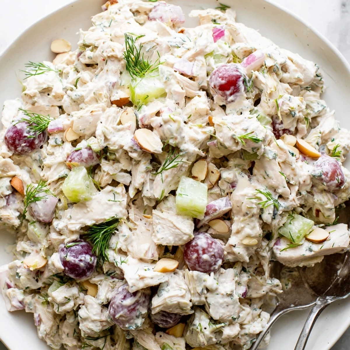 Vibrant vegan chicken salad scooped over crisp lettuce with grapes and almonds
